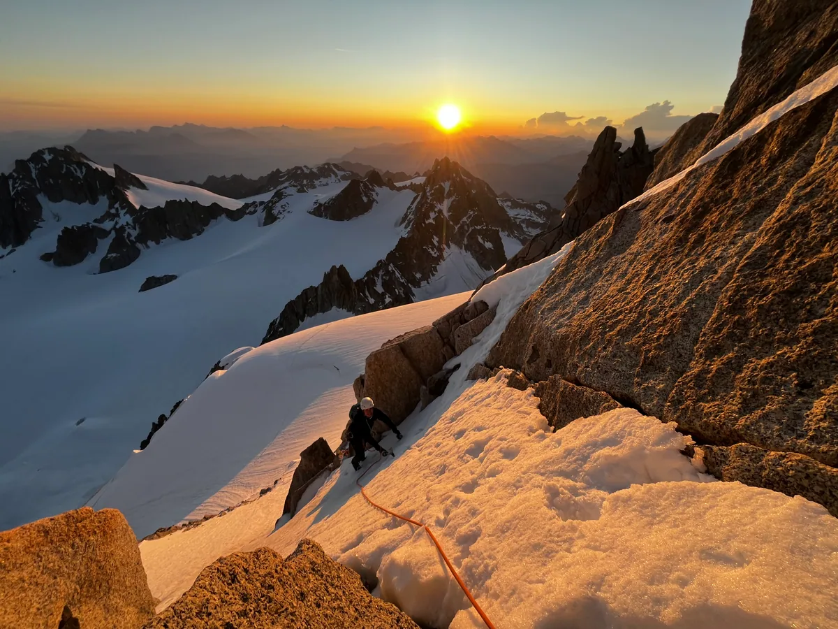 La lumière du lever de soleil éclaire la neige et les aiguilles en montagne