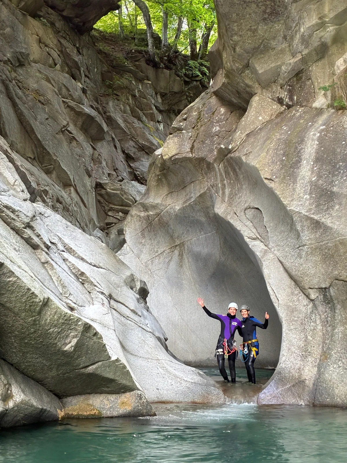Deux participants dans une gorge sculptée, au-dessus d’une eau turquoise